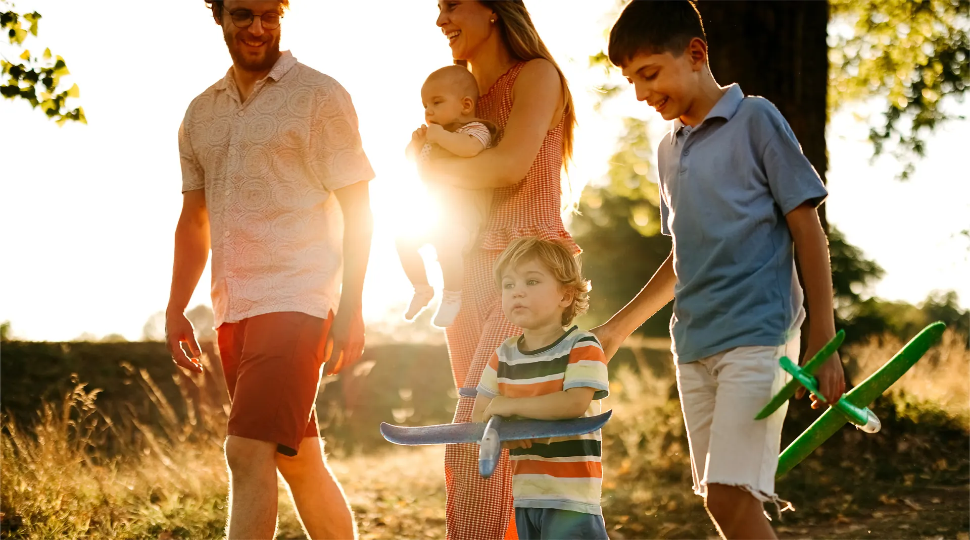 Lifestyle photograph labelled Caledon Station in the Bolton Place marketing set — a family walking outdoors near Bolton, Caledon. Not a rendering of a detached house.